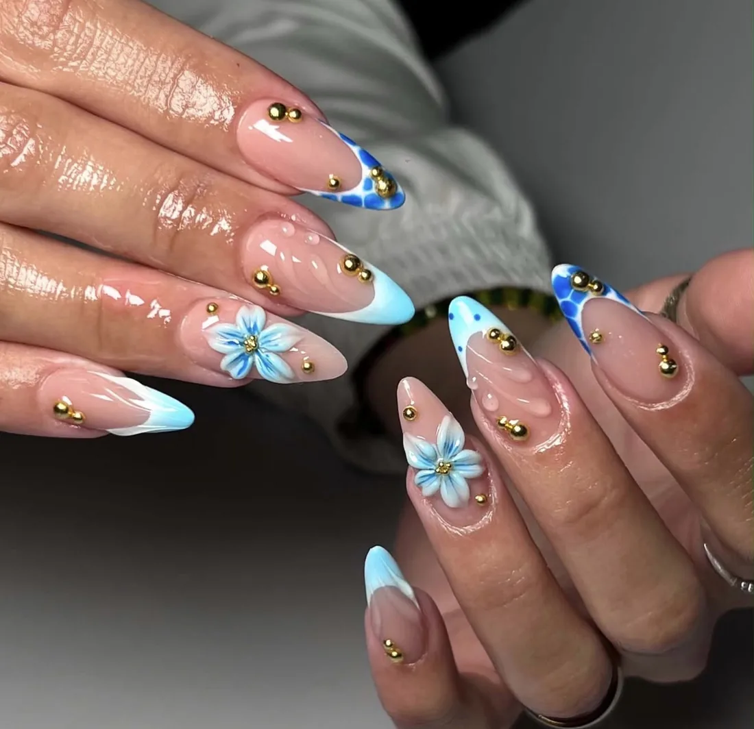Light blue French tips with floral art and gemstone accents