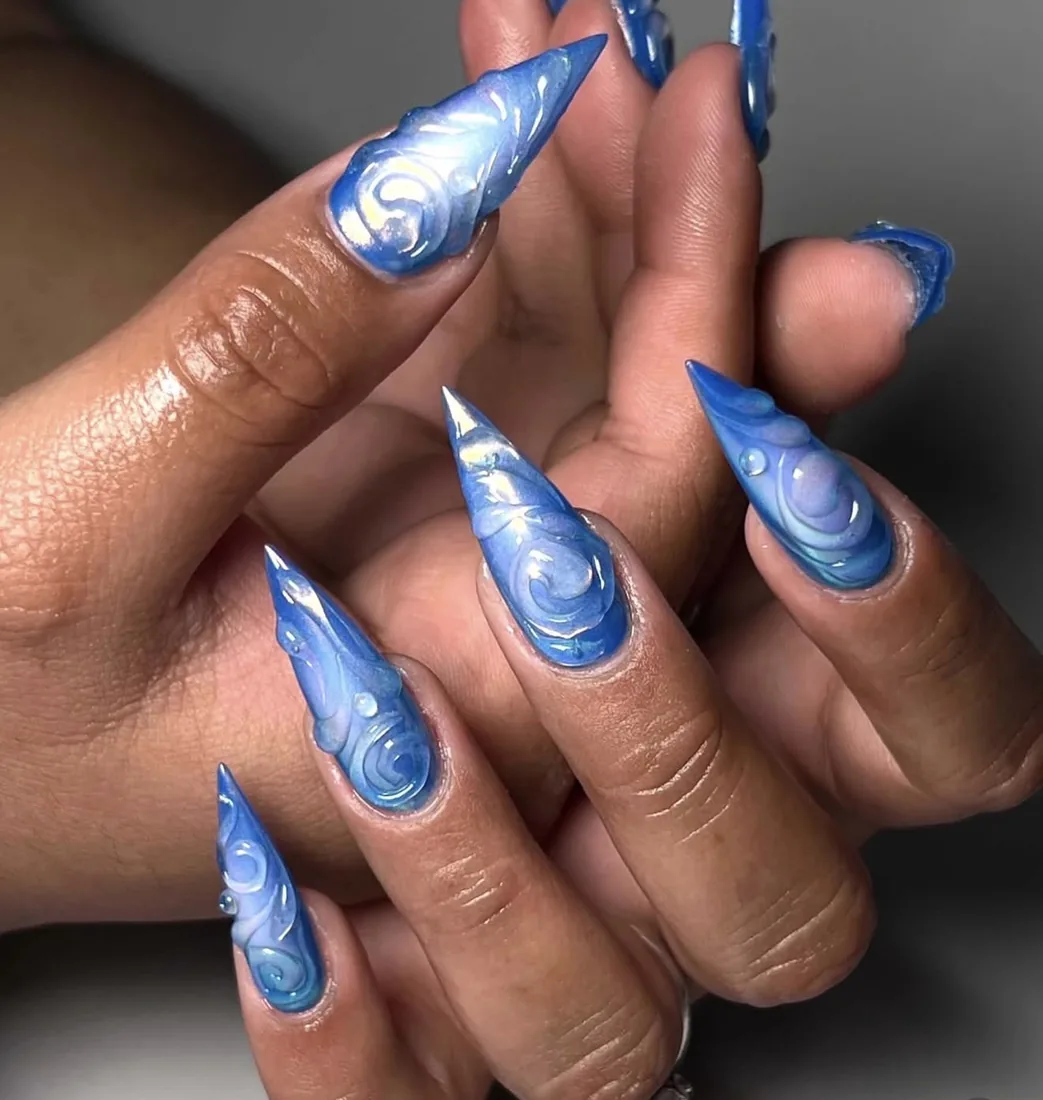 Stiletto nails in a swirled blue and white marble finish