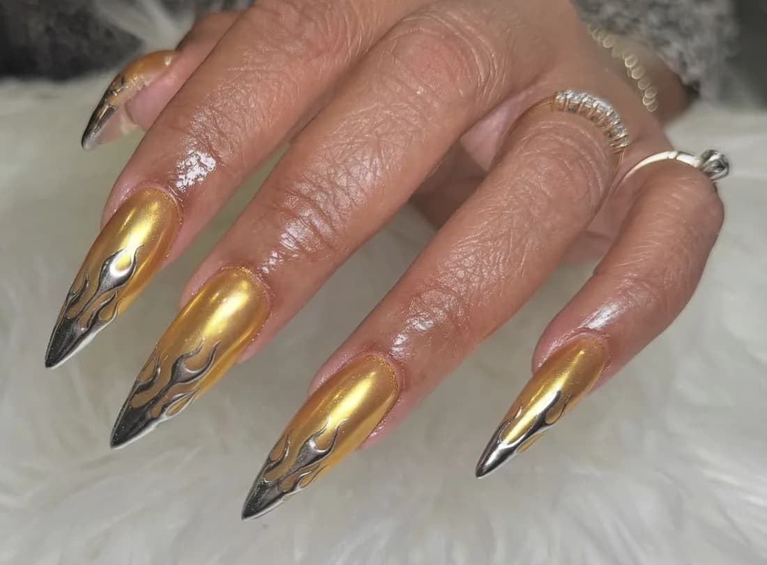 Stiletto nails in gold chrome with black tips